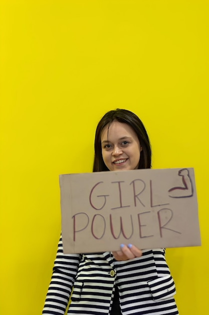 Isolated girl holding empowerment sign An isolated empowered girl holding a feminism sign Concept of a woman holding a Women in Power sign