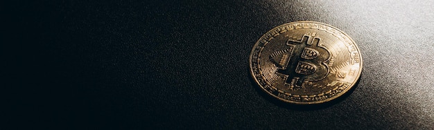 Isolated golden bitcoin on black background with reflection copy space