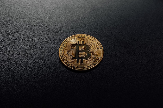 Isolated golden bitcoin on black background with reflection copy space