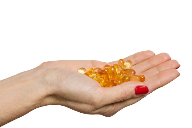 Isolated hand holding capsule of Omega 3 