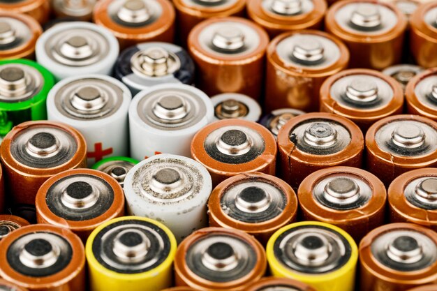 Isolated old battery leakage, hazardous waste concept. Energy abstract background of colorful batteries.