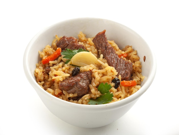 Isolated pilaf with meat, carrot, garlic and barberry in the bowl