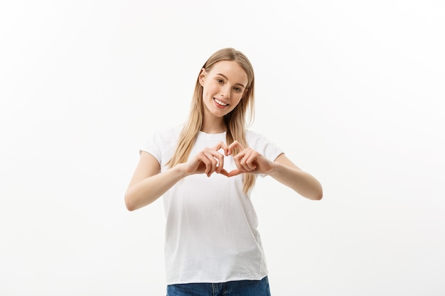 Isolated portrait of beautiful caucasian woman make heart symbol by hands.