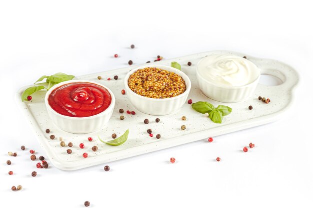 Isolated sauce ketchup dijon mustard and mayonnaise in bowls