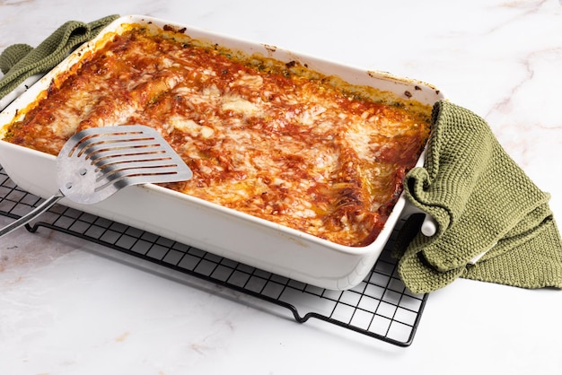 An isolated serving of vergetarian lasagna in a white casserole dish