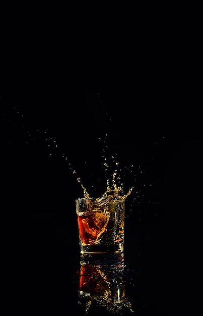 Isolated shot of whiskey with splash on black background