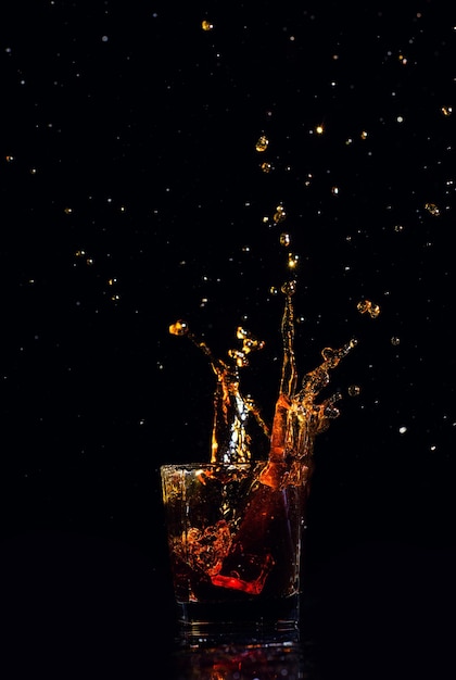 Isolated shot of whiskey with splash on black background