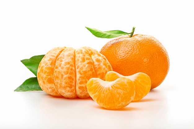 Isolated tangerines. Half of peeled tangerine and whole mandarin or orange fruit with green leaves isolated on white background. Close up.