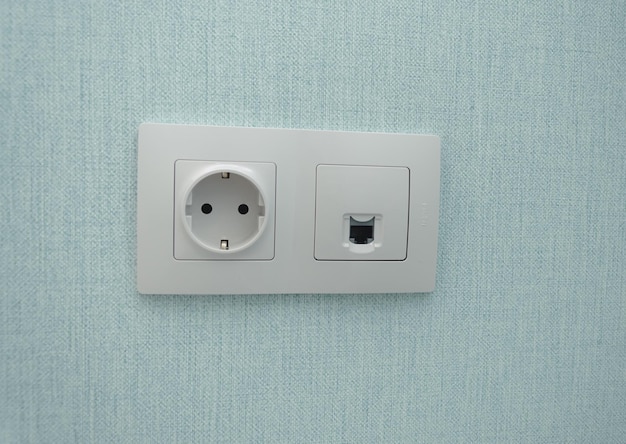 Isolated white beige switch and socket on a light wall aesthetics of electrics repair security interior design place for text