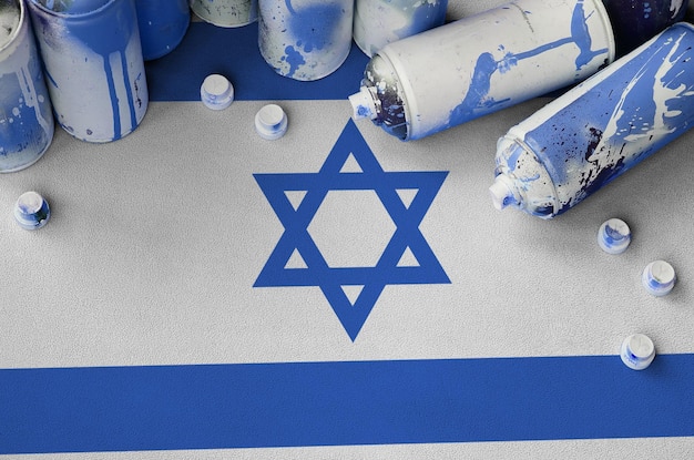 Israel flag and few used aerosol spray cans for graffiti painting Street art culture concept