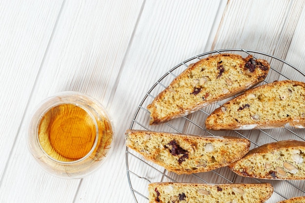 Italian biscotti cookies on baking rack and sweet wine Vin Santo Fresh baked cookies with nuts