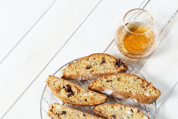 Italian biscotti cookies on baking rack and sweet wine Vin Santo.