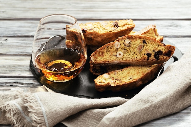 Italian biscotti cookies on black slate board and sweet wine Vin Santo Fresh baked cookies