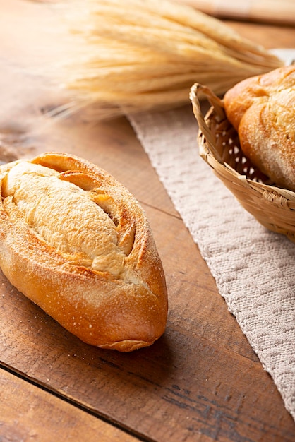 Photo italian bread on rustic wood with wheat branches