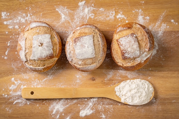 Italian bread with wooden spoon and wheat flour on wooden table