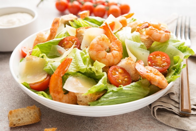 Italian caesar salad with shrimp, croutons and parmesan, close up