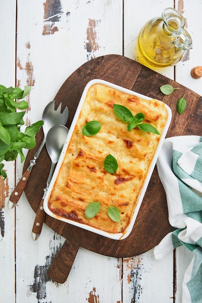 Photo italian cannelloni pasta casserole cannelloni with ground chicken tomato and bechamel sauce traditional italian pasta dish and recipe cover or article top view place for text