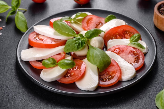 Italian caprese salad with sliced tomatoes, mozzarella cheese, basil, olive oil