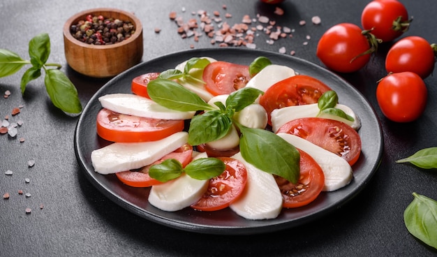 Italian caprese salad with sliced tomatoes, mozzarella cheese, basil, olive oil