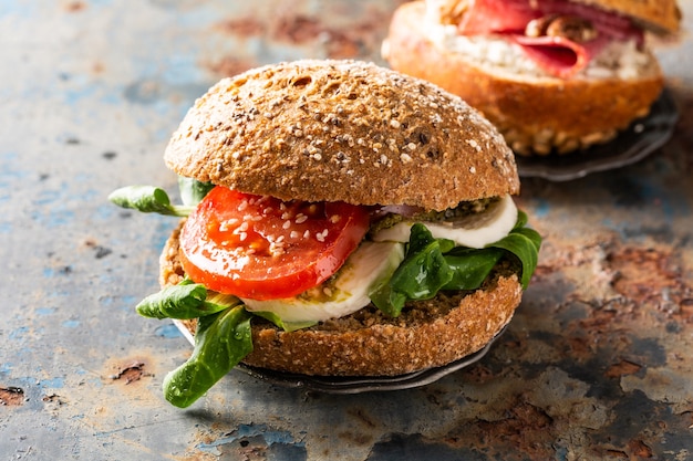 Italian Caprese sandwiches with fresh tomatoes, mozzarella cheese and lamb's lettuce, multigrain bun