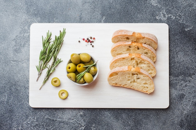 Italian ciabatta bread with olives and rosemary on a cutting Board 