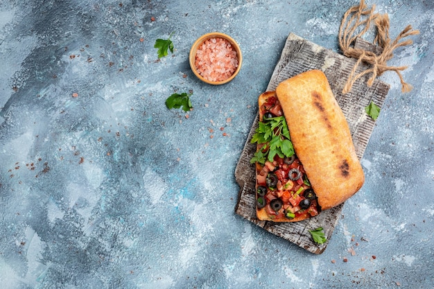 Italian ciabatta with chopped tomato vegetables, herbs and oil on grilled or toasted crusty baguette. Italian bruschetta. banner, menu, recipe place for text, top view.