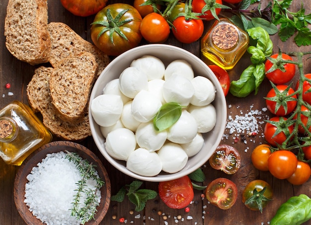 Italian cooking ingredients mozzarella, tomatoes, basil, olive oil and other top view