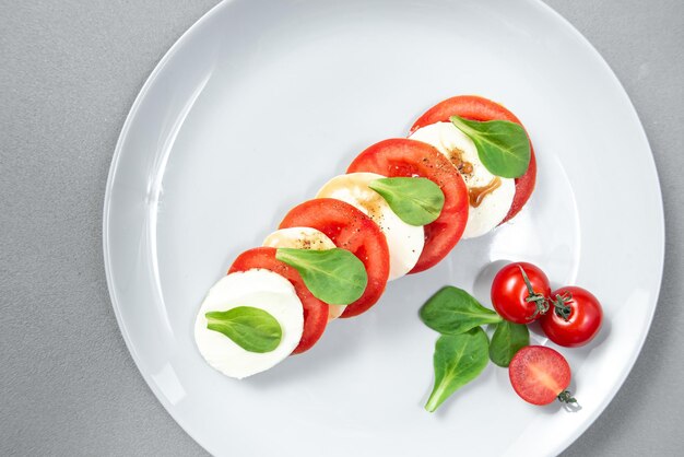 Italian cuisine traditional italian cuisine caprese salad on a gray plate on a gray background