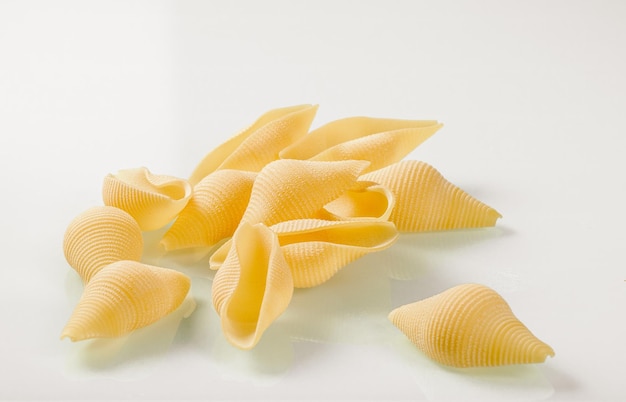 Italian cuisinebunch of shell shaped pasta on a white glass background