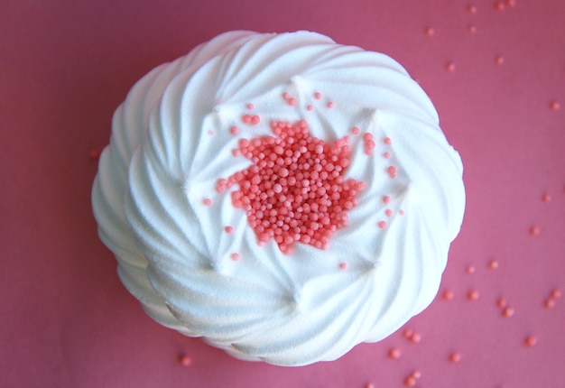 italian dessert white meringues on a pink background