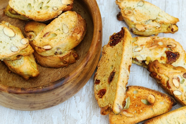 Italian dry cookies cantucci or biscotti with nuts and figs in wooden bowl.