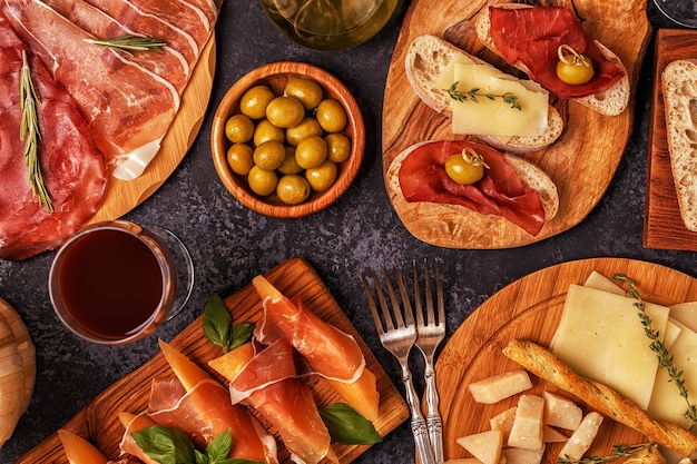 Italian food  with ham, cheese, olives, bread, wine.