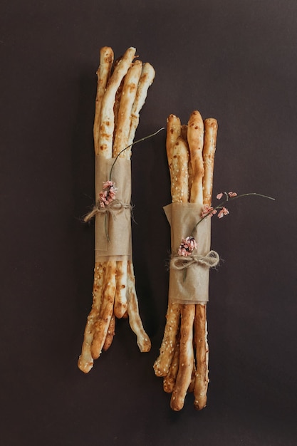 Italian grissini or salted bread sticks on brown background