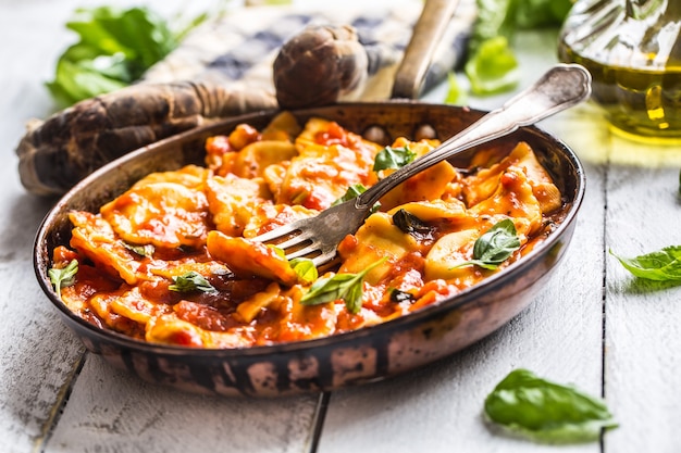 Italian or mediterranean food pasta ravioli of tomato sauce and basil.