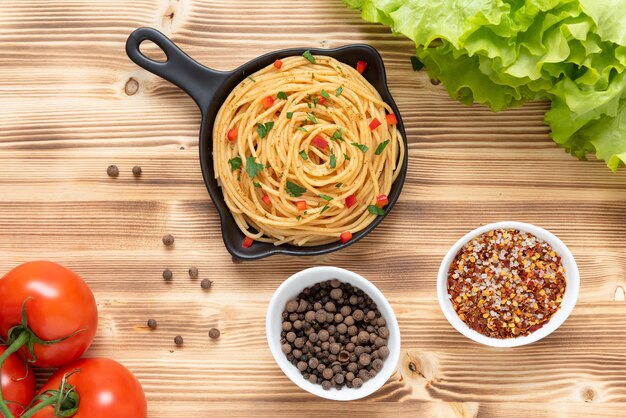 Italian pasta in a frying pan on a light wooden background