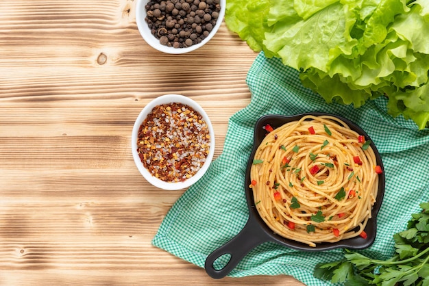 Italian pasta in a frying pan on a wooden background Top view