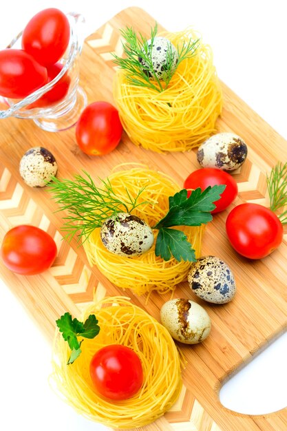 Italian pasta nests with cherry tomatoes and quail eggs.