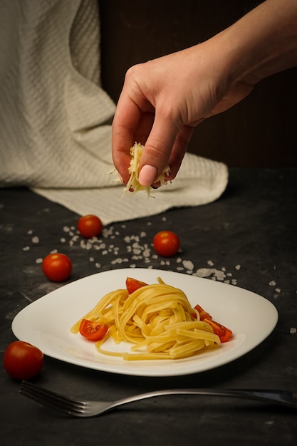 Italian pasta on a plate on a dark  with cherry tomatoes