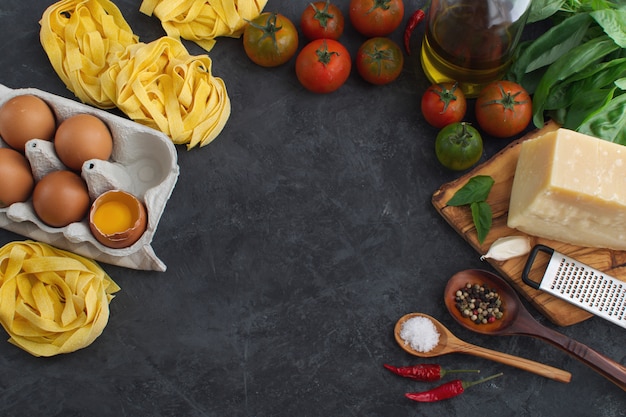 Italian pasta and sauce ingredient  top view on dark background