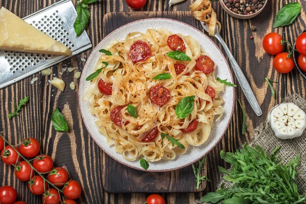 Italian pasta with sauce, cherry tomatoes, basil and parmesan cheese. Delicious pasta plate