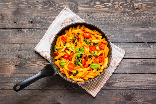 Italian penne pasta in tomato sauce and different type of vegetables