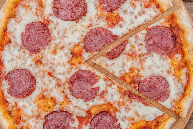 Italian Pepperoni pizza with salami on dark wooden background top view Italian traditional food Popular street food