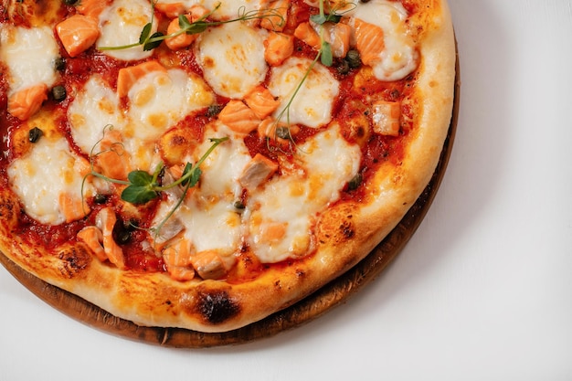 Italian pizza with cheese onions and salmon on a white background closeup Copyspace