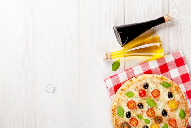 Italian pizza with cheese tomatoes olives and basil