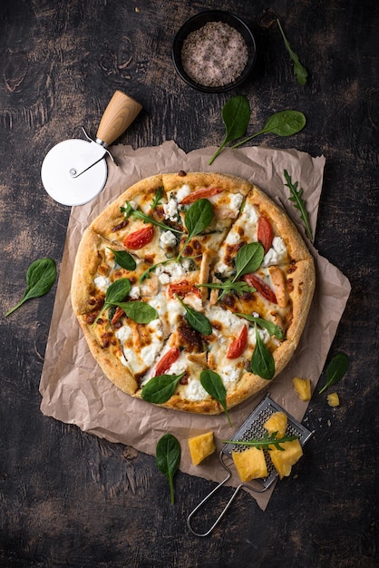 Italian pizza with feta cheese tomato and basil