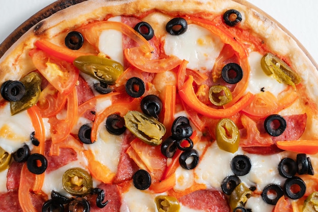 Italian pizza with ham olives peppers and herbs closeup