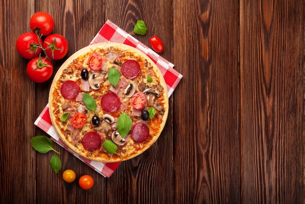 Italian pizza with pepperoni tomatoes olives and basil