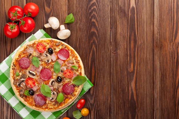 Italian pizza with pepperoni tomatoes olives and basil