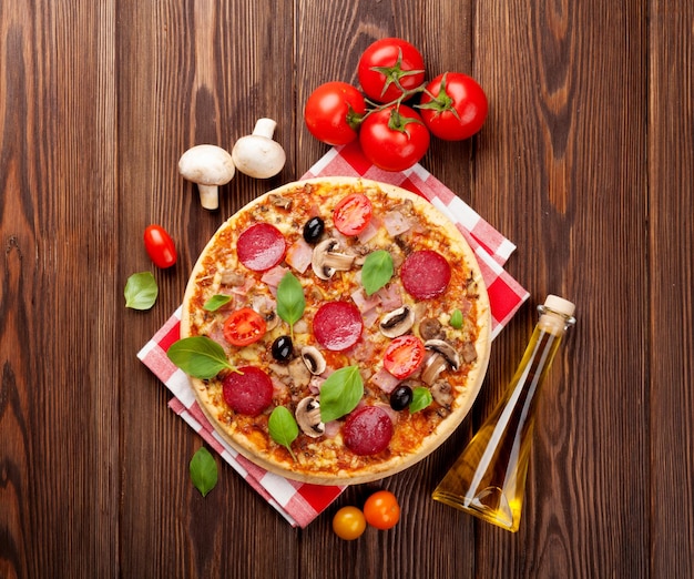 Italian pizza with pepperoni tomatoes olives and basil