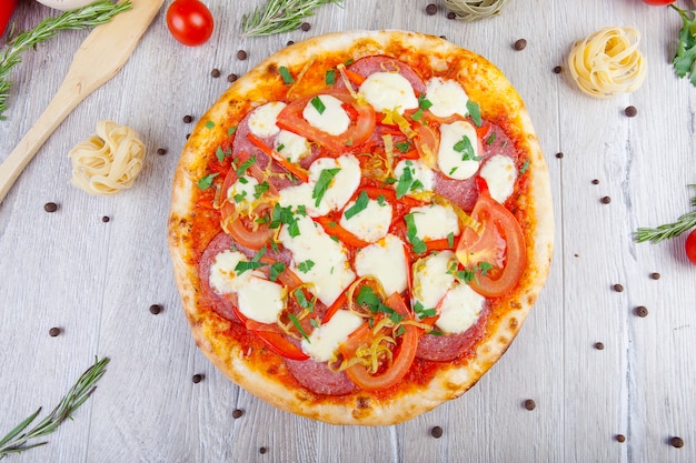 italian pizza on a wooden background with decoration around